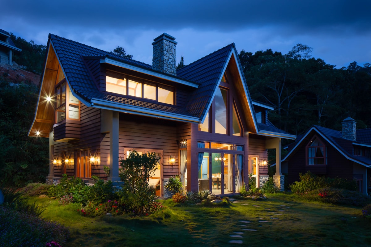 A warmly lit craftsman home at dusk with a steep, well-built roofline. TODO: replace with a Bill Ragan project photo.